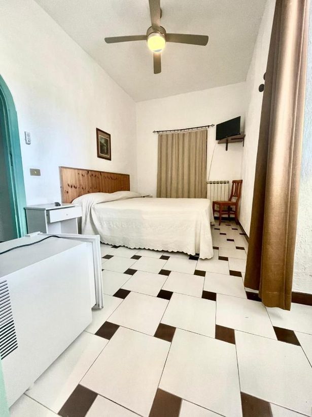 Camera con ventilatore a soffitto e pavimento a scacchi bianco e nero