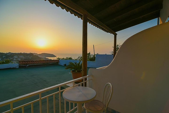 Tramonto dorato sul mare da una terrazza con pergolato