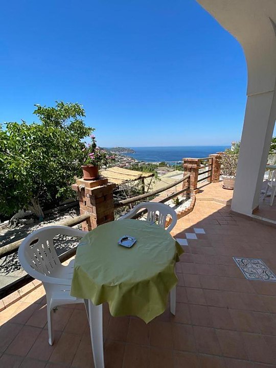 Angolo terrazza con tavolino affacciato sul mare tra il verde